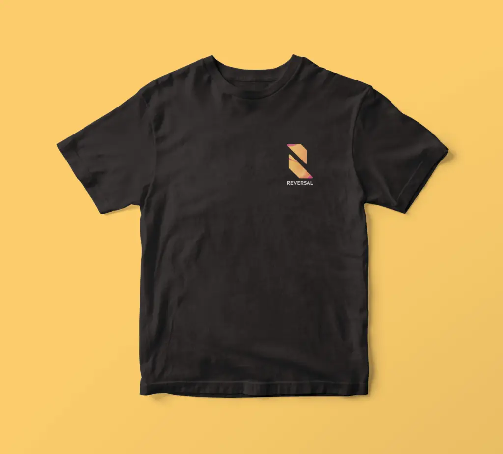 "Mockup of a black t-shirt with a colorful design featuring shades of pink and orange. The shirt is displayed on a plain white background, and the design is prominent on the front of the shirt. The combination of the dark fabric and bright colors creates a bold and eye-catching look."